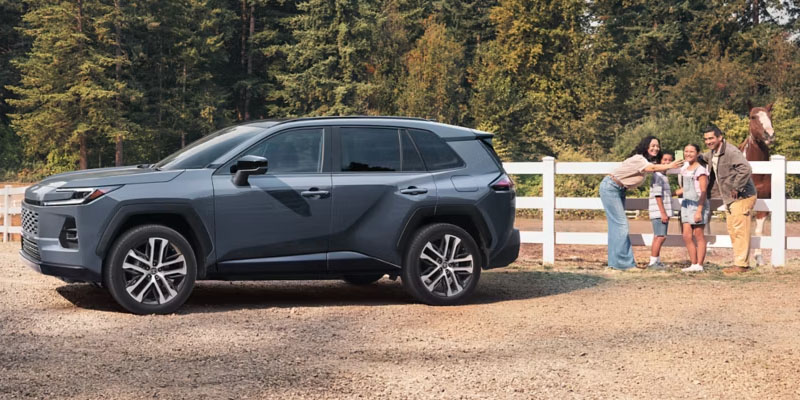 2026 Toyota RAV4 parked near family outdoors.