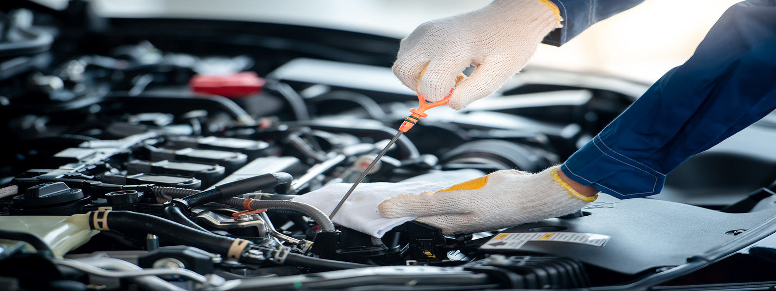 Automotive technician checking engine fluids