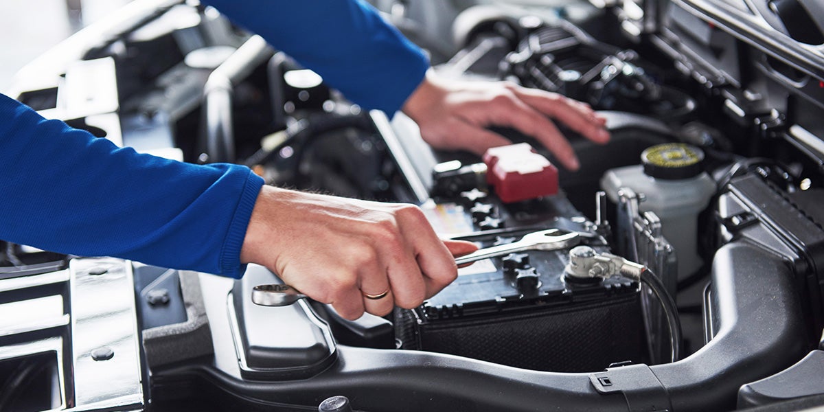 Mechanic's hands working on an engine.